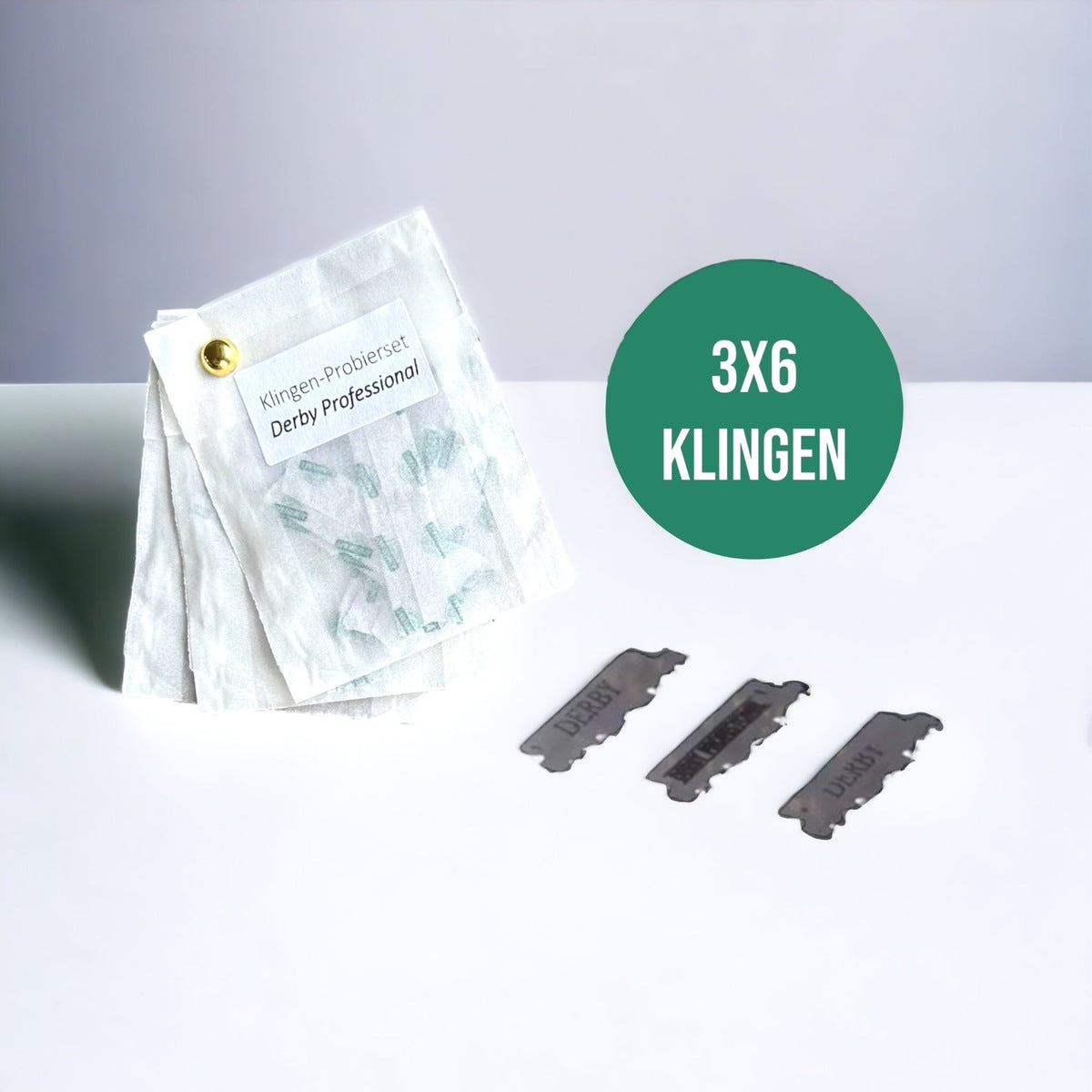 Das SHAVENT Gesichtspflege-Ritual-Set mit Derby Professional Rasierklingen zeigt 3 von 6 Doppelklingen in Papierschutzhüllen, fixiert mit einem Messingverschluss.