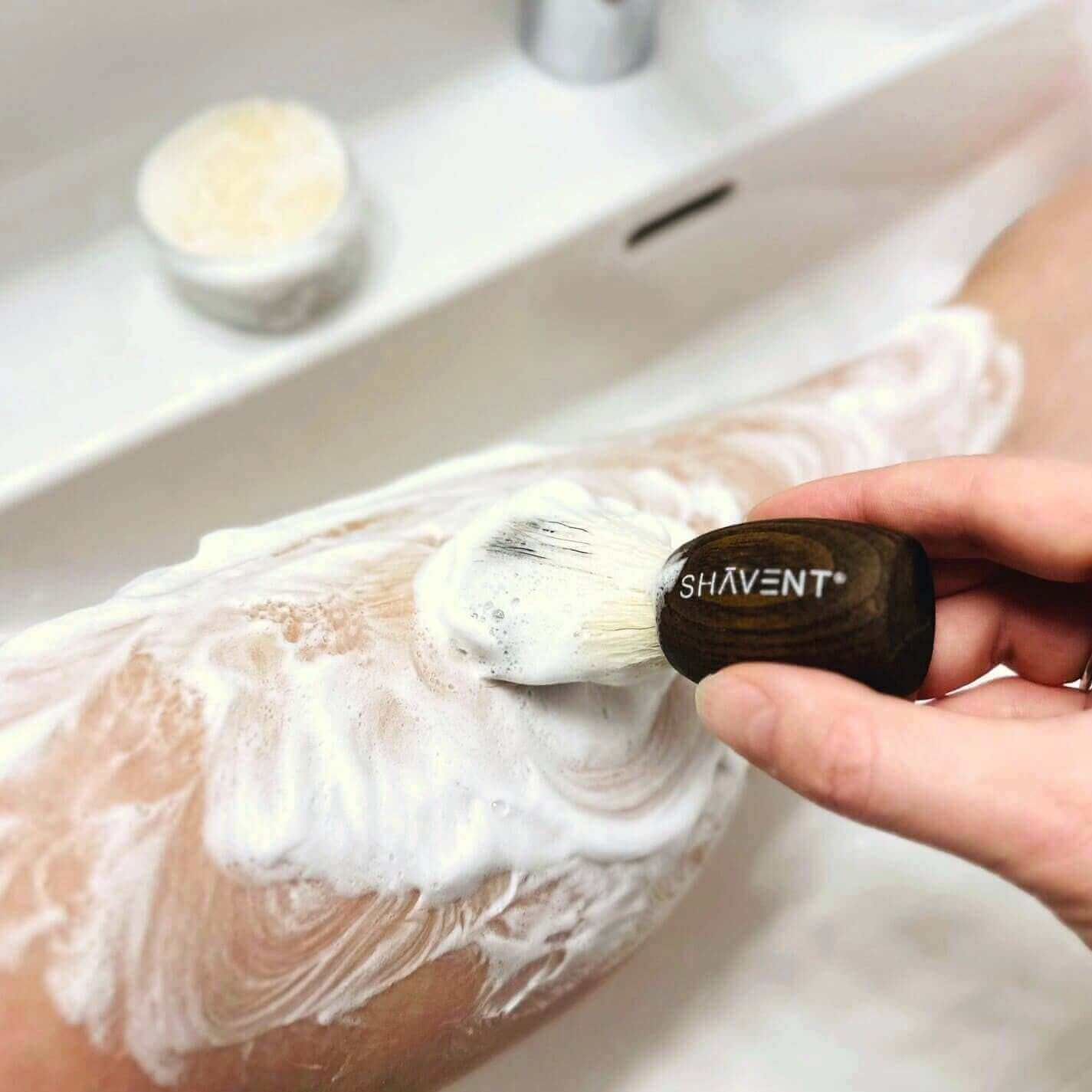 SHAVENT Lemon Silk Rasierseife: Person schäumt Bein mit cremig-milder Seife ein. Ideal für sanfte, hautschonende Rasur mit frischem Zitronenduft.