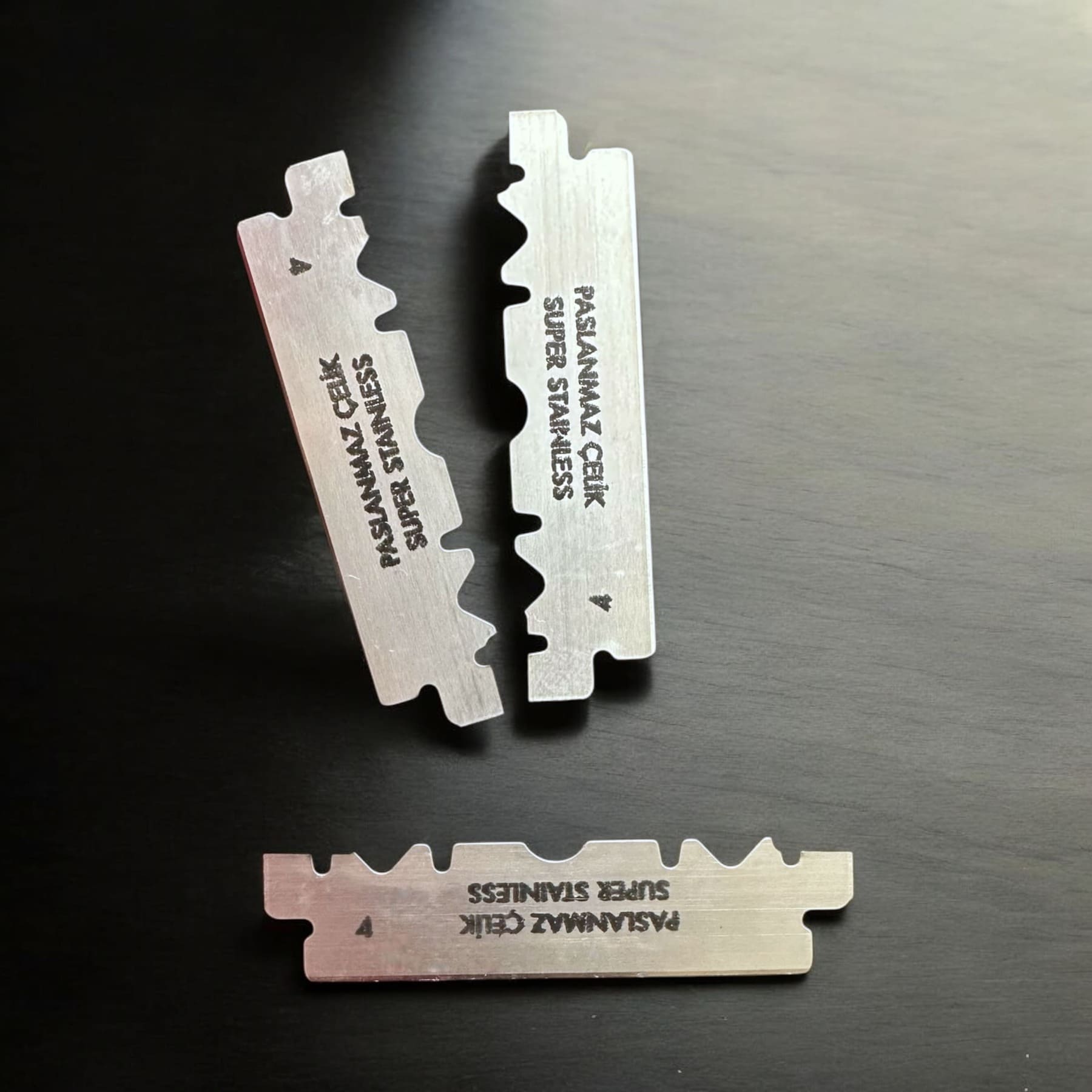 Drei doppelschneidige Rasierklingen aus Edelstahl, geprägt mit PASLANMAZ CELIK SUPER STAINLESS, passend zum SHAVENT Face Shave Ritual für eine perfekte Rasur.