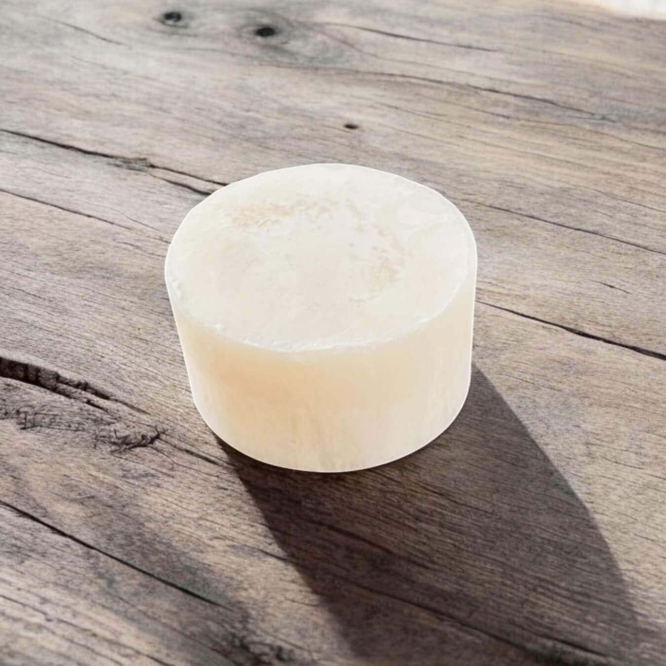 SHAVENT Grooming Oster-Special: Runde, cremefarbene Rasierseife auf Holztisch, Teil eines Sets für beruhigte, gepflegte Haut nach der Rasur.