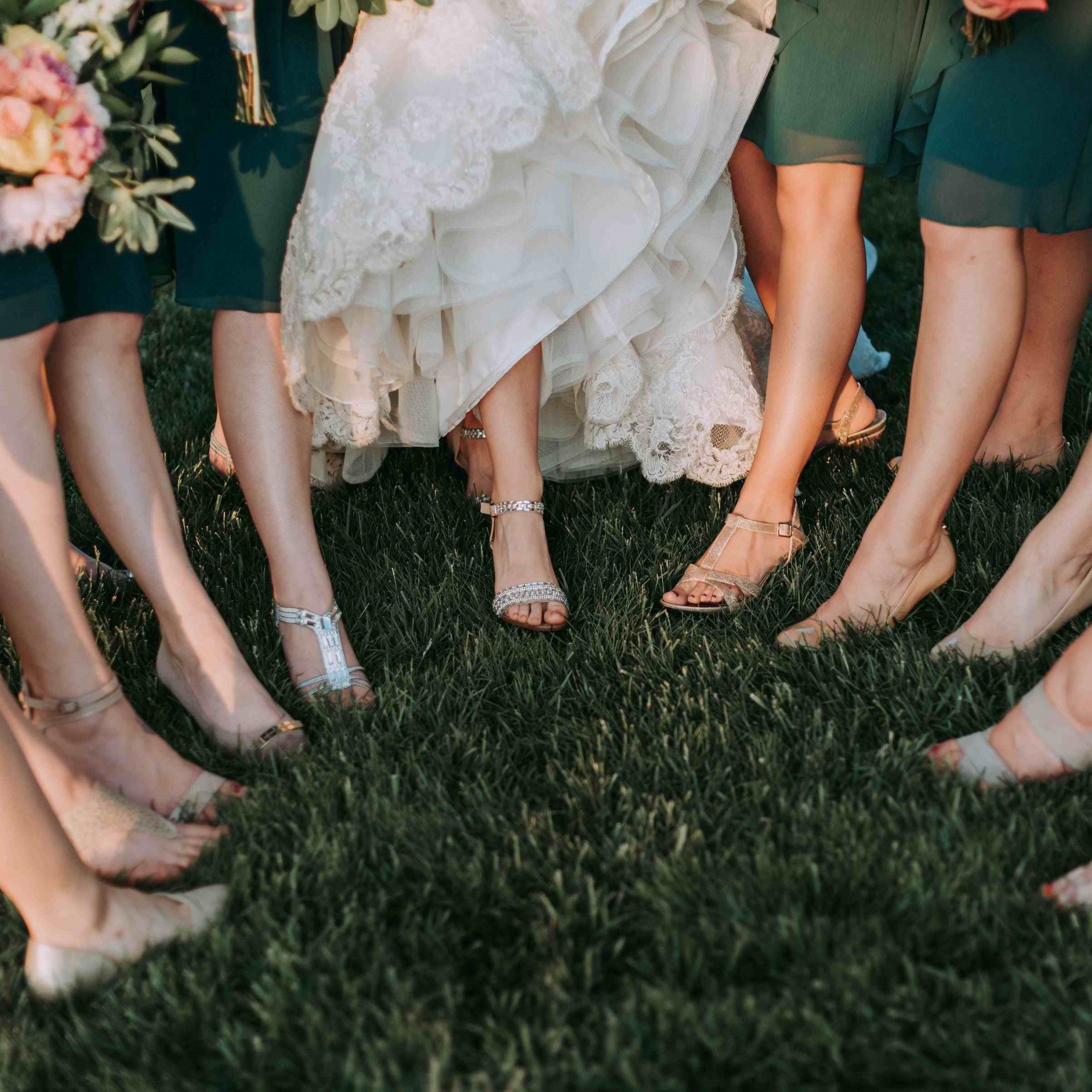 Frauen stehen mit rasierten Beinen zur Hochzeit im Kreis