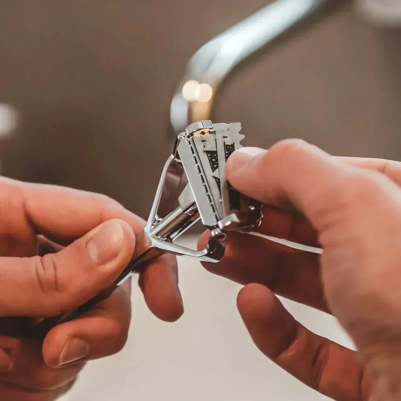 Nahaufnahme eines SHAVENT Edelstahlrasierers beim Einlegen einer Standard-Halbklinge