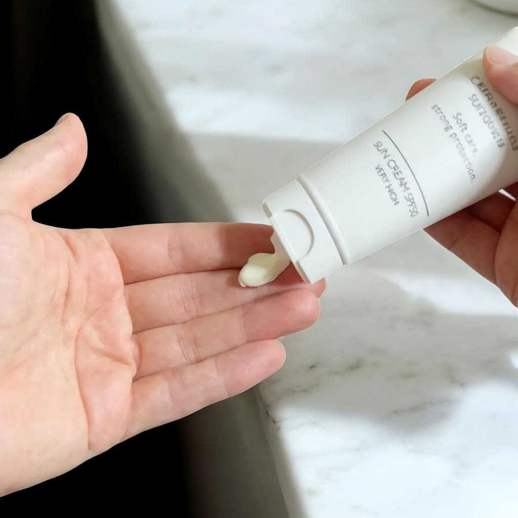 Hand hält weiße SHAVENT Calm & Protect Sonnencreme SPF50, ideal für sanften Schutz nach der Rasur, ohne Brennen oder Kleben, mit Karanjaöl und schnellem Einziehen.